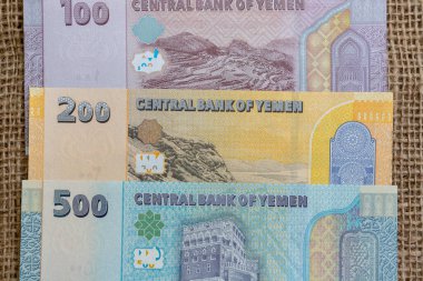 Yemenli 500, 200 ve 100 'lük banknotları bir çuval bezi yüzeyi üzerinde topladı.