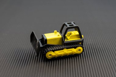 Siyah Arkaplanda Minyatür Sarı Buldozer Oyuncağı