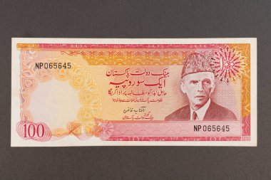 Old 100 Rupees Pakistani Banknote with Quaid-e-Azam Portrait on Black Background (No longer in circulation). clipart