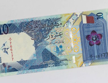 Katar 10 riyali geleneksel geometrik desenli banknot, Katar bayrağı, Katar florası (Dreama). Doha 'daki Katar Devlet Camii' nin giriş kapısı.