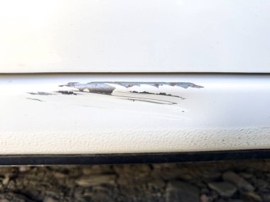 Arabanın gövdesinde çizikler var, arabanın alt kısmında yakın plan çekimde.