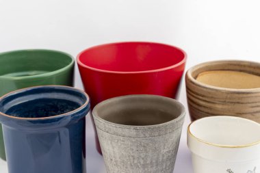 Beyaz arka planda izole edilmiş çiçek saksılarının çeşitli boyutları ve renkleri. Yeşil, kırmızı, kahverengi, mavi, gri ve beyaz, beyaz arkaplanda seramik boş tencereler