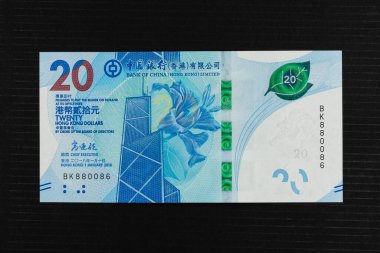 Hong Kong twenty dollar Bank of China currency note. The front panel of the HK$20 banknote features a bauhinia flower and Bank of China Tower against a pattern of tea leaves. clipart