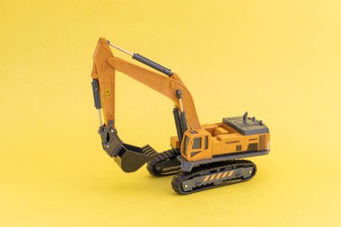 Sarı arkaplanda izole edilmiş bir kazıcı modeline yakın plan