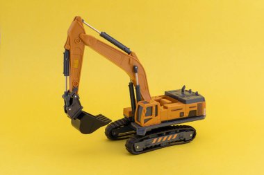 Sarı zemin üzerinde minyatür kazıcı ölçeği modeli