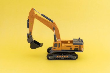 Sarı arkaplanda bir oyuncak kazıcı modelinin yan görünümü.
