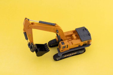 Sarı arkaplanda bir oyuncak kazıcısının yüksek açılı görünümü