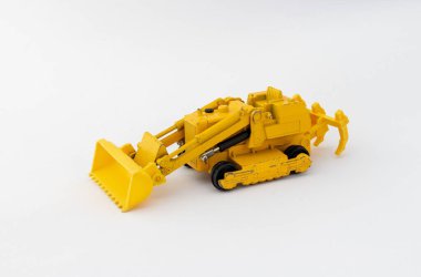 Kum ve çakıl taşımak için büyük kovalı sarı oyuncak buldozer. Ağır inşaat makineleri.