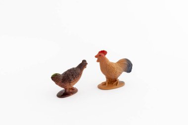 Beyaz izole edilmiş arka planda minyatür bir horoz ve tavuk plastik oyuncağı