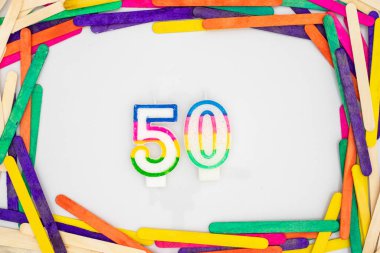 50 numaralı doğum günü mumları renkli çubuklarla beyaz arkaplanda çerçeve kenarlığı