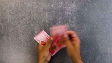 Pakistan 'ın 100 rupilik banknotlarını tutan ve sayan bir adamın yakın çekimi..