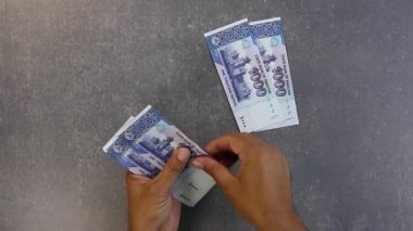 Pakistanlı 1000 rupi sayıyorum. Tasarruf ve yatırım kavramı.