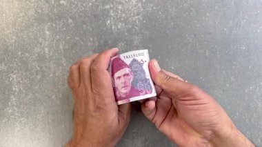 Eller para sayıyor. Pakistan 'a 50 rupi sayıyorum. Yakın çekim genel görünüm