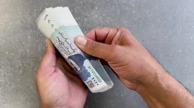 Pakistan 'ın 1000 banknotluk banknotlarını sayan adam