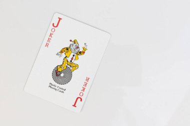 Beyaz arkaplanda kopyalama alanı olan kırmızı şakacı oyun kartı