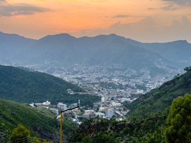 Pakistan Swat Vadisi 'nde Sunset' te Yeşil Dağlarla çevrili Manzaralı Şehir Manzarası.