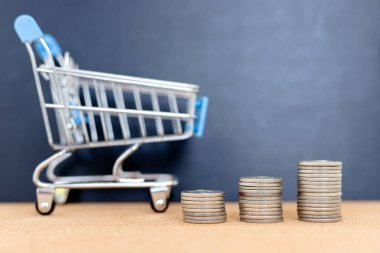 Harcama ve Perakende Harcama Harcamalarını Sembolize eden Birikmiş Bozukluklarla Küçük Alışveriş Aracı Metinleriniz için Boş Alan ile Masraflar.