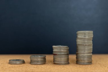 Karanlık Arkaplanda Dört Para Yığını. Mali İlerleme ve Ekonomik Karşılaştırma Sembolü.