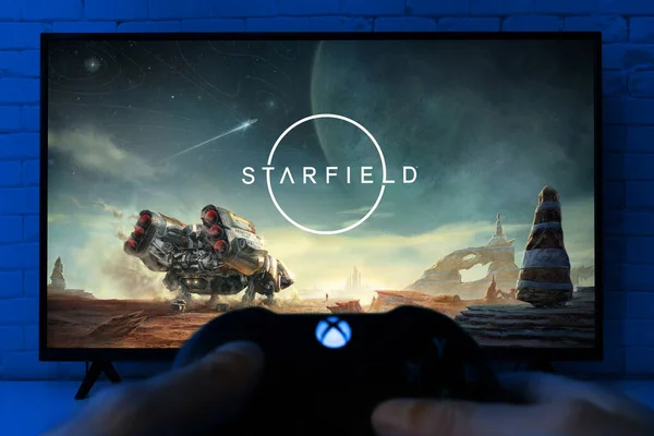 Man Playing Starfield Παιχνίδι Μπροστά Από Την Τηλεόραση Χειριστήριο Xbox — Φωτογραφία Αρχείου