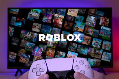Kid playing Roblox on TV screen with Playstation 5 controller, 3 oct, 2023, Sao Paulo, Brazil. clipart