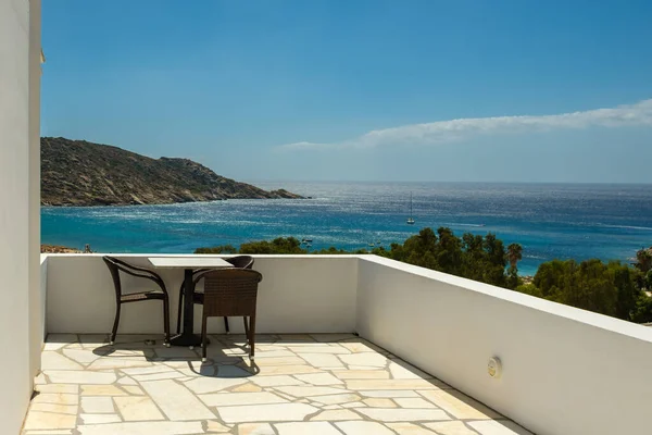 Sandalyeli bir balkon ve Yunanistan 'ın ünlü Mylopotas plajına bakan bir masa.