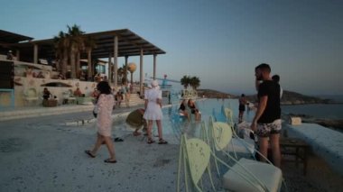 Ios, Yunanistan - 10 Eylül 2022: Yunanistan 'ın Ios kentindeki ünlü Pathos bar restoranında dans eden ve parti yapan turistler