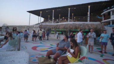 Ios, Yunanistan - 10 Eylül 2022: Yunanistan 'ın Ios kentindeki ünlü Pathos bar restoranında dans eden ve parti yapan turistler