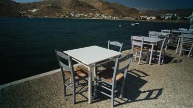 Yunanistan 'ın limanında deniz kenarında rahat sandalyeler ve masalar manzarası