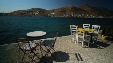 Yunanistan 'ın limanında deniz kenarında rahat sandalyeler ve masalar manzarası