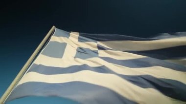 Rüzgarda dalgalanan büyük Yunan bayrağı ve arka planda mavi bir gökyüzü