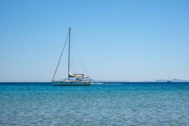 Ios, Yunanistan - 14 Eylül 2022: Yunanistan 'daki ünlü Mylopotas plajında bir yelkenli