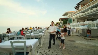 Afitos, Yunanistan - 1 Eylül 2022: Afitos Chalkidiki Yunanistan 'da çarpıcı manzaralı pitoresk restoranlarda akşam yemeği yiyip içen turistler