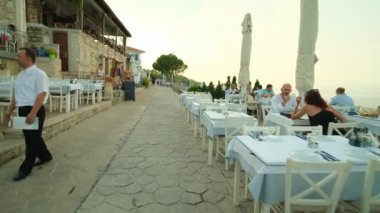 Afitos, Yunanistan - 1 Eylül 2022: Afitos Chalkidiki Yunanistan 'da çarpıcı manzaralı pitoresk restoranlarda akşam yemeği yiyip içen turistler