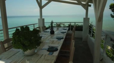 Kriopigi, Yunanistan - 31 Ağustos 2022: Yunanistan 'ın Chalkidiki kentindeki Kriopigi plajına bakan güzel dekore edilmiş bir yemek masasının manzarası
