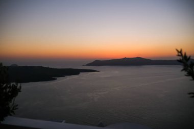 Fira Santorini 'nin çatılarından muhteşem bir gün batımı manzarası.