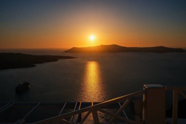 Fira Santorini 'nin çatılarından muhteşem bir gün batımı manzarası.