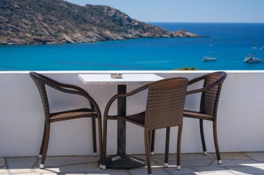 Yunanistan 'ın ünlü Mylopotas plajına bakan sandalyeli bir balkondan harika bir manzara.