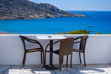 Yunanistan 'ın ünlü Mylopotas plajına bakan sandalyeli bir balkondan harika bir manzara.