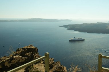 Santorini, Greece - September 16, 2022 : Panoramic view of a cruise ship next to the volcano and a beautiful blue sky in Santorini Greece