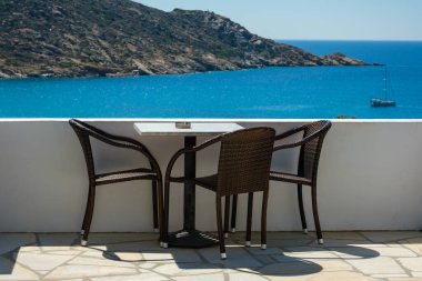 Yunanistan 'ın ünlü Mylopotas plajına bakan sandalyeli bir balkondan harika bir manzara.