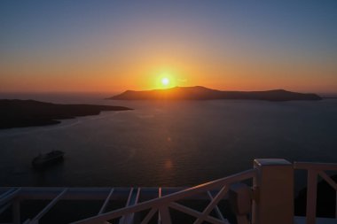Fira Santorini 'nin çatılarından muhteşem bir gün batımı manzarası.