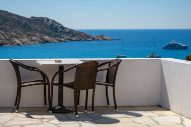 Yunanistan 'ın ünlü Mylopotas plajına bakan sandalyeli bir balkondan harika bir manzara.