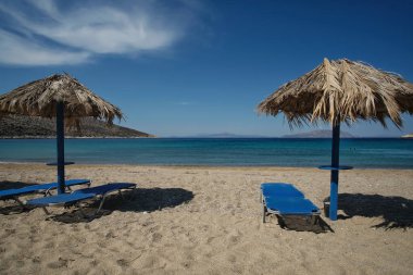 Sun beds and sun umbrellas at the amazing beach of Agia Theodoti in Ios Greece