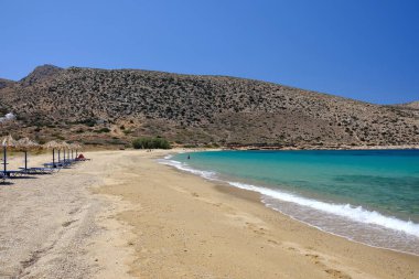 Ios, Greece - June 6, 2021 : Tourists enjoying the sandy beach of Agia Theodoti in Ios Greece