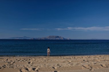 Sun beds and a sun umbrellas at the amazing beach of Agia Theodoti in Ios Greece