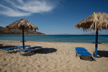 Sun beds and a sun umbrellas at the amazing beach of Agia Theodoti in Ios Greece