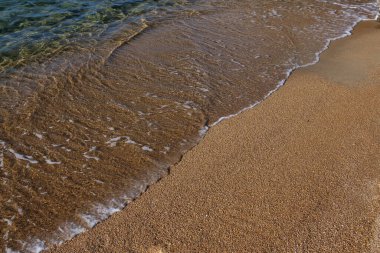 Close up view of the golden sandy beach and the clear waters of Mylopotas in Ios Cyclades Greece