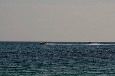 Ios, Yunanistan: 30 Mayıs 2021: Yunanistan 'ın ünlü Mylopotas Sahili' nde bir jet ski ile denizden geçen turistler