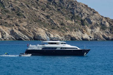 Ios, Yunanistan - 30 Mayıs 2021: Yunanistan 'daki Mylopotas plaj ve su sporları faaliyetlerinde lüks bir yat manzarası