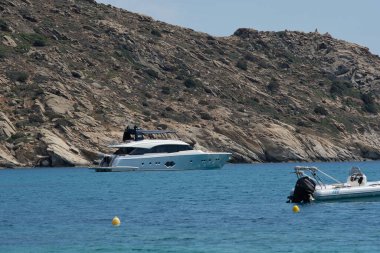 Ios, Yunanistan - 30 Mayıs 2021: Yunanistan 'daki Mylopotas plajında bir sürat teknesi ve yat manzarası